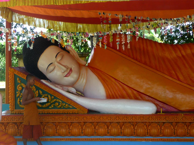 Jóven orando junto a Buda reclinado