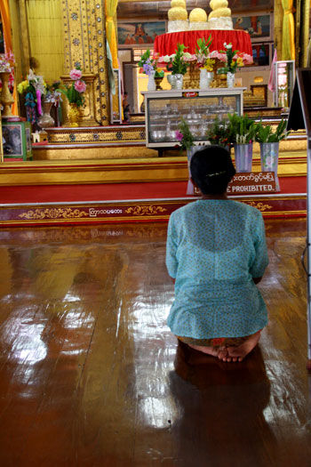 Mujer rezando a una distancia prudencial